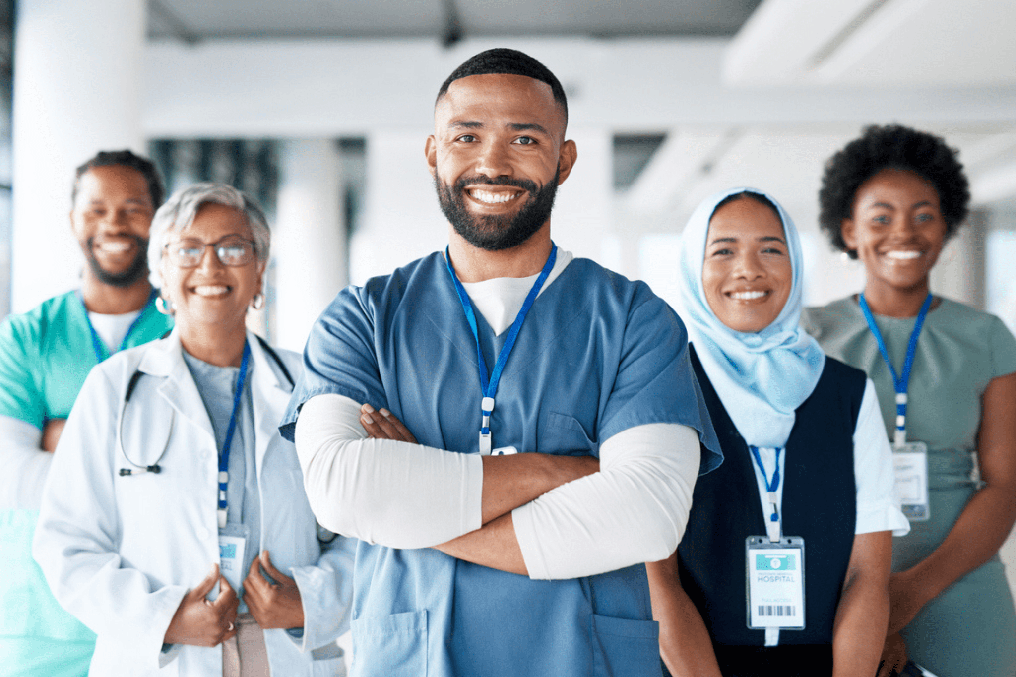 Group of 5 nurses standing in a v-shape smiling
