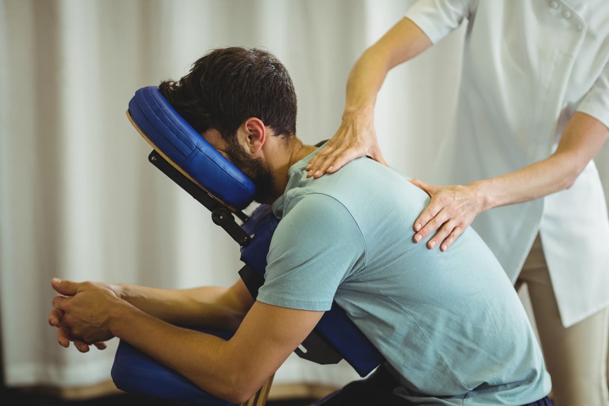 Side view of a customer receiving a chair massage.